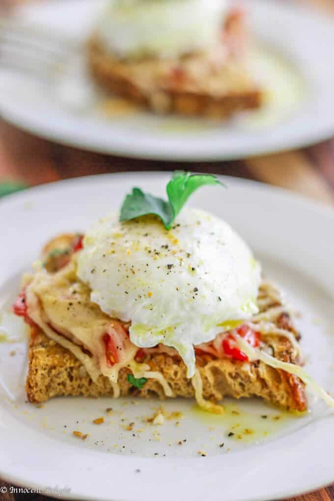 Poached Egg on Parmesan Tomato Toast is a delightful breakfast option. Runny egg yolk infuses with the tomatoes and herbs, and is beautifully balanced by a crusty parmesan topping - making for an irresistibly perfect breakfast bite.