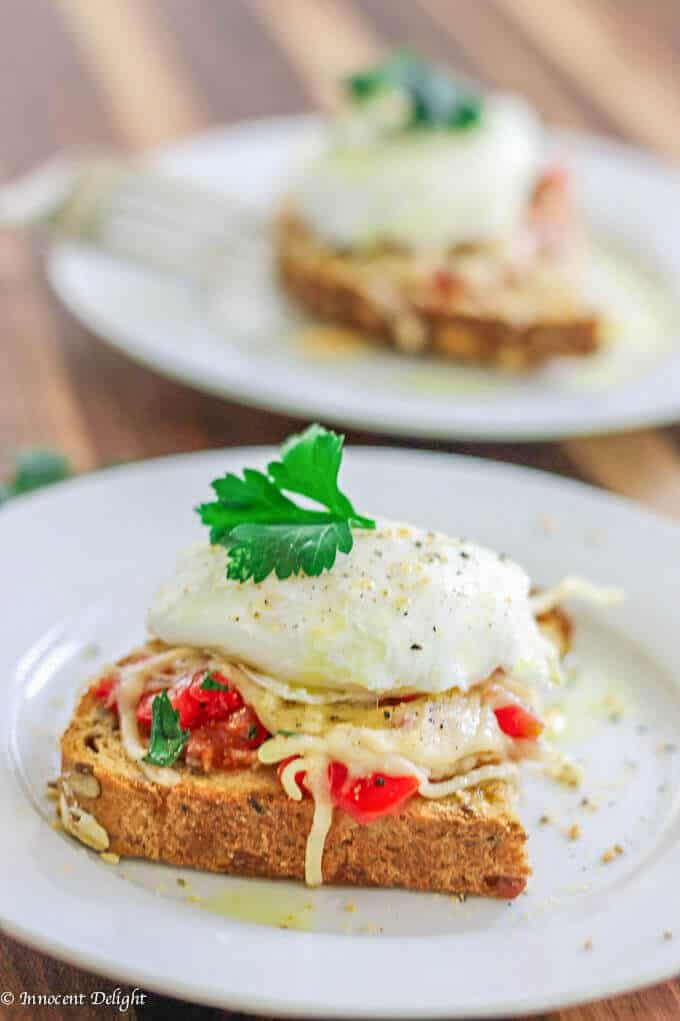 Poached Egg on Parmesan Toast is an amazing breakfast option. Soft runny egg yolk on the tomatoes and herbs with almost crusty parmesan topping makes for irresistible perfect breakfast bite. 