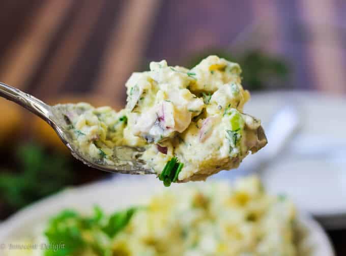 Potato Salad with eggs and pickles on a fork