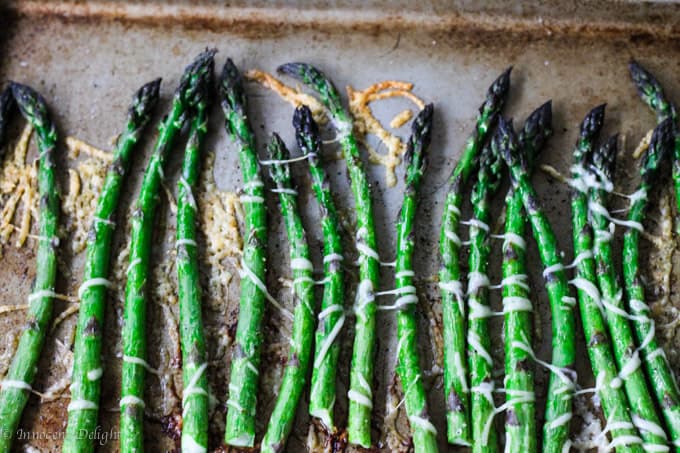 Roasted asparagus with Parmesan Cheese on a sheet pan, vertical photo