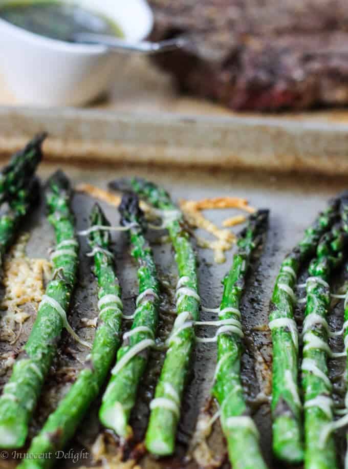 Roasted asparagus with parmesan cheese on a sheet pan straight shot