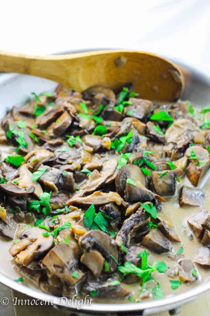 Creamy Mushroom Sauce with wild and fresh mushrooms in a skillet with spoon. 