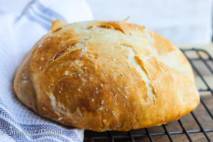 Homemade Dutch Oven Crusty Bread on a rack and towel