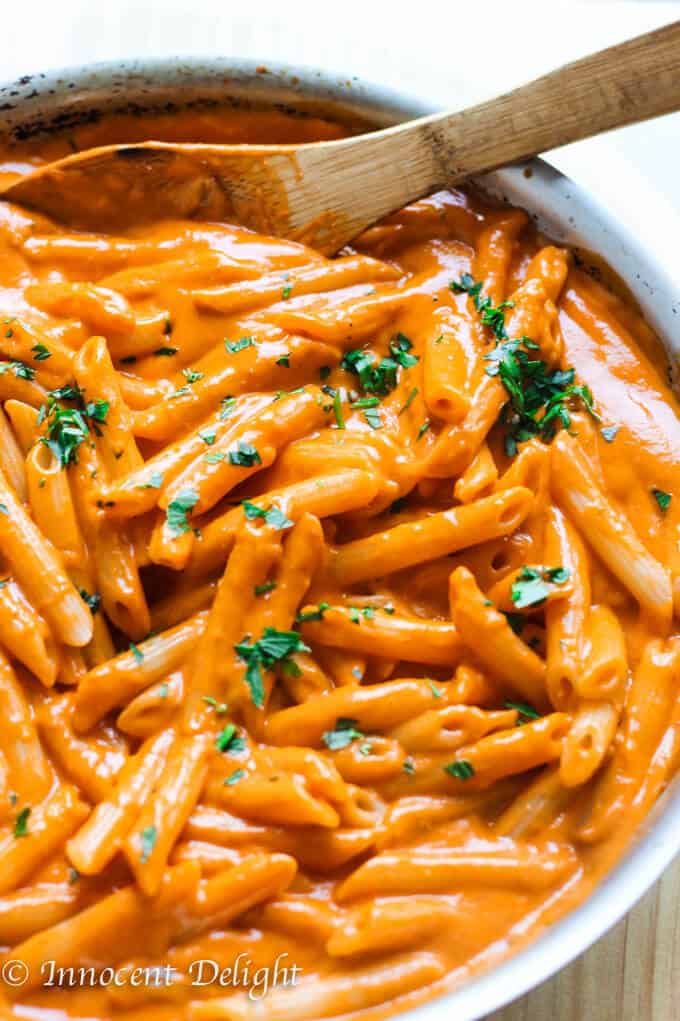 Pasta in vodka sauce in a skillet with wooden spoon