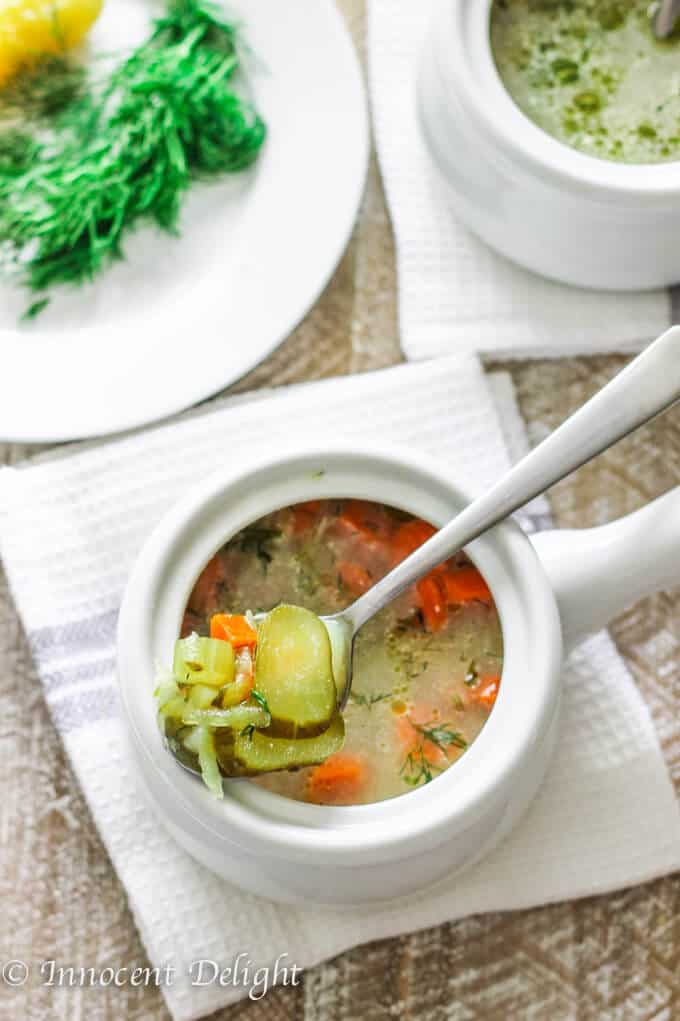 Soupe de cornichons à l'aneth polonais dans deux bols avec une cuillère dans l'un d'eux ramassant les cornichons