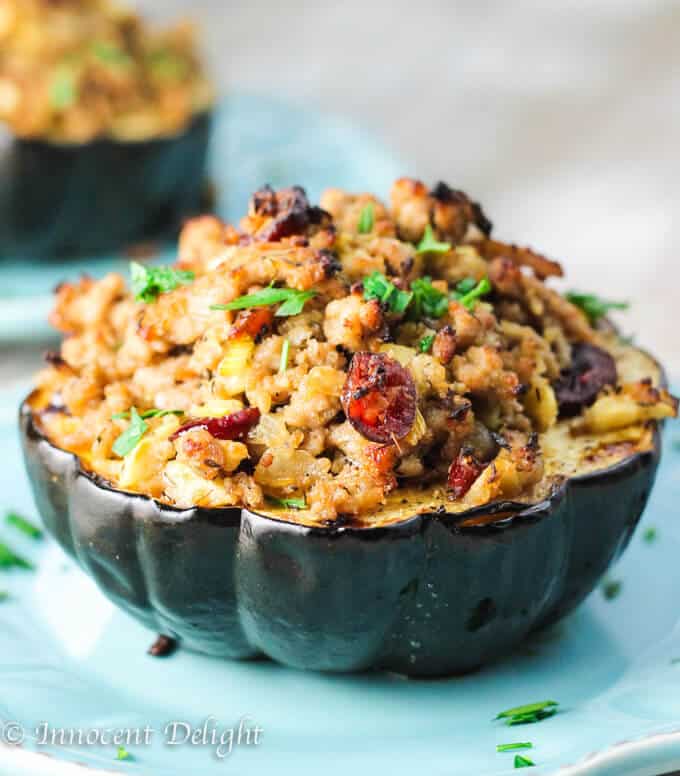 Turkey Stuffed Acorn Squash with apples, cranberries and thyme on blue plate