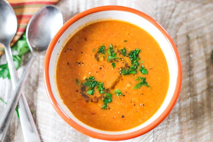  Tomatoes Red Lentils Coconut Soup in a bowl with spoons on a side