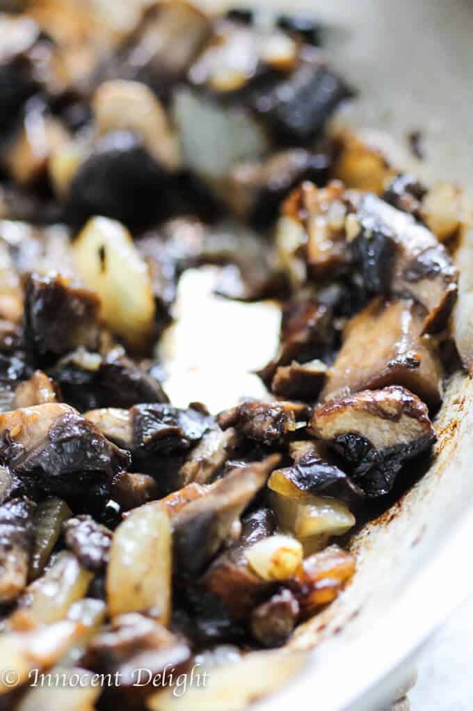 Sautéed portabello mushrooms with onions on a pan