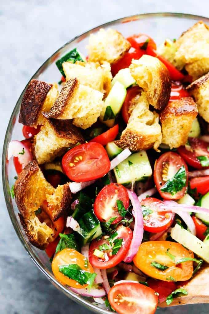 Panzanella Salad with garlic bread, tomatoes, onions and cucumber in a glass bowl