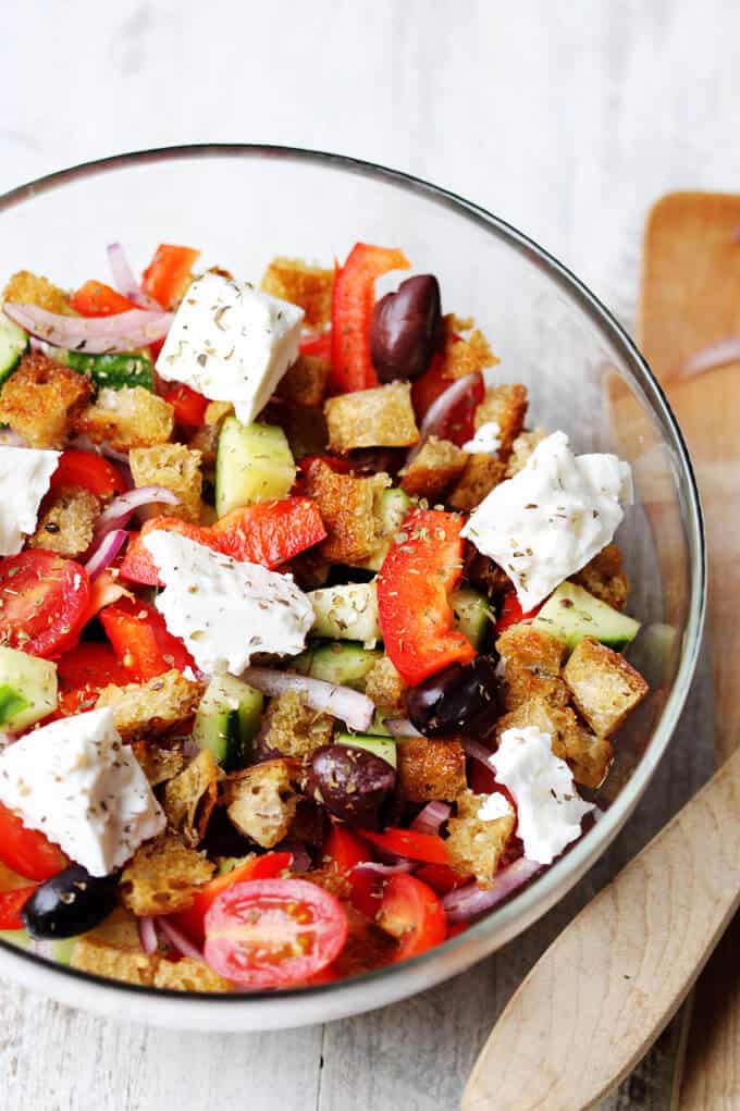 Greek salad with bread cubes in a bowl; 