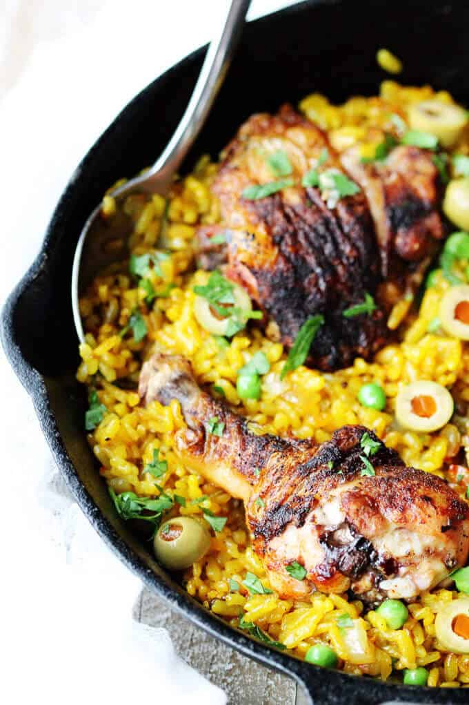 Spanish chicken with saffron rice and olives in a skillet