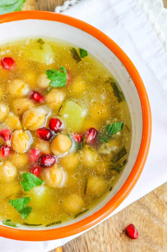 Greek Chickpea Soup in a bowl with kitchen towel on a side