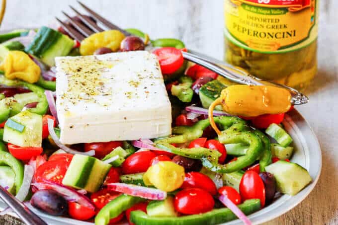 Horiatiki Salad with Golden Greek Peperoncini coHoriatiki Salad with Golden Greek Peperoncini combines the freshest ingredients of seasonal tomatoes, cucumbers, green peppers, red onions, tangy kalamata olives and creamy feta with mildly piquant, fruity flavor Mezzetta Peperoncini. #DontForgettaMezzetta #Mezzetta #Ad