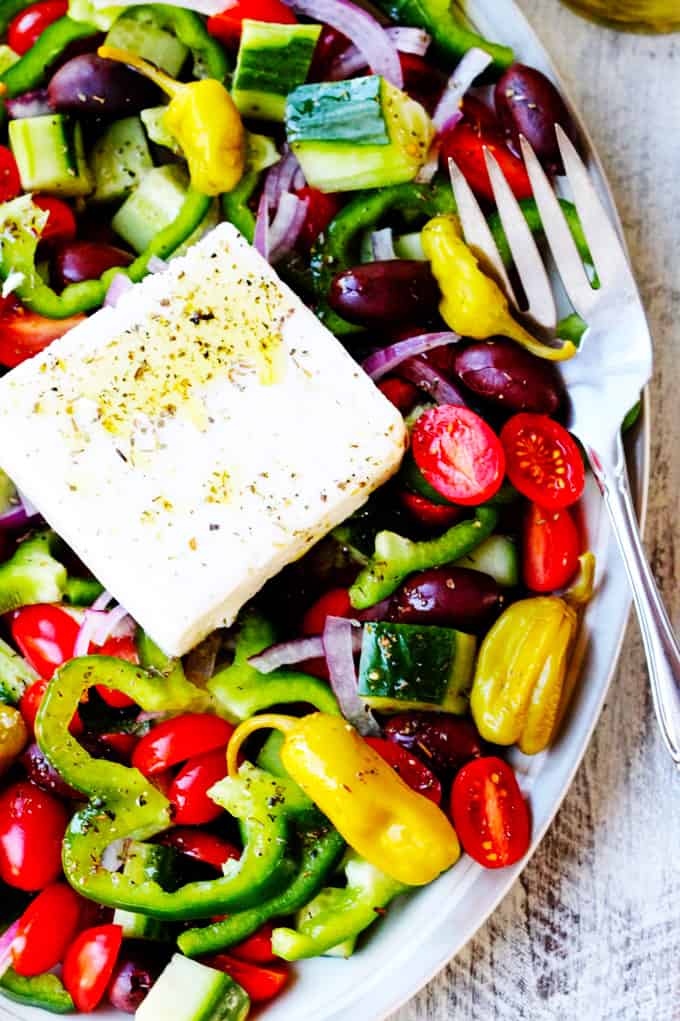 Horiatiki Salad or Greek Salad on a plate with feta and fork