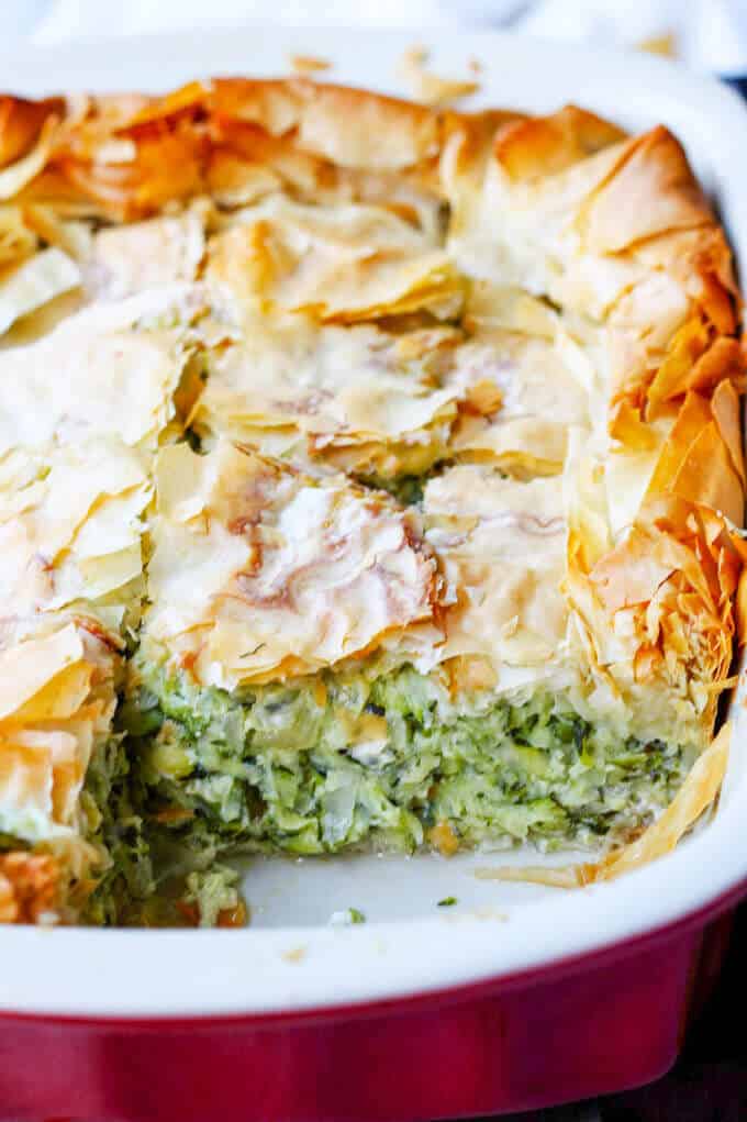 Greek zucchini pie in a red casserole dish, close up photo