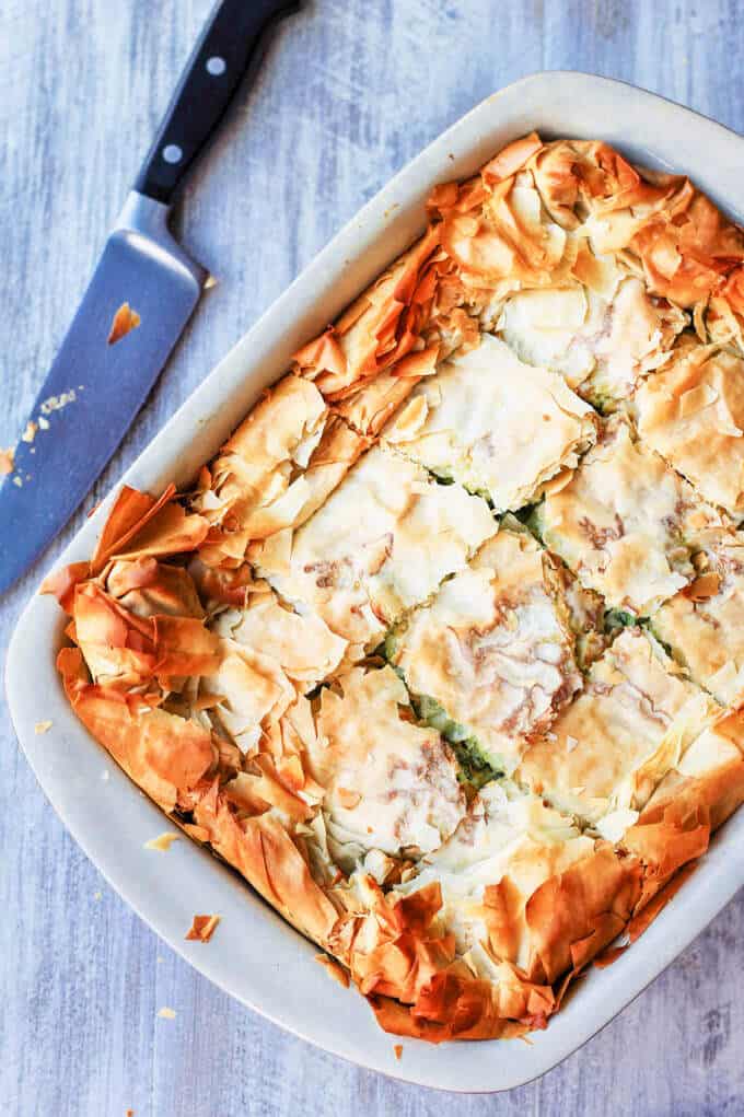 Greek Kolokithopita in a casserole dish with knife next to the dish