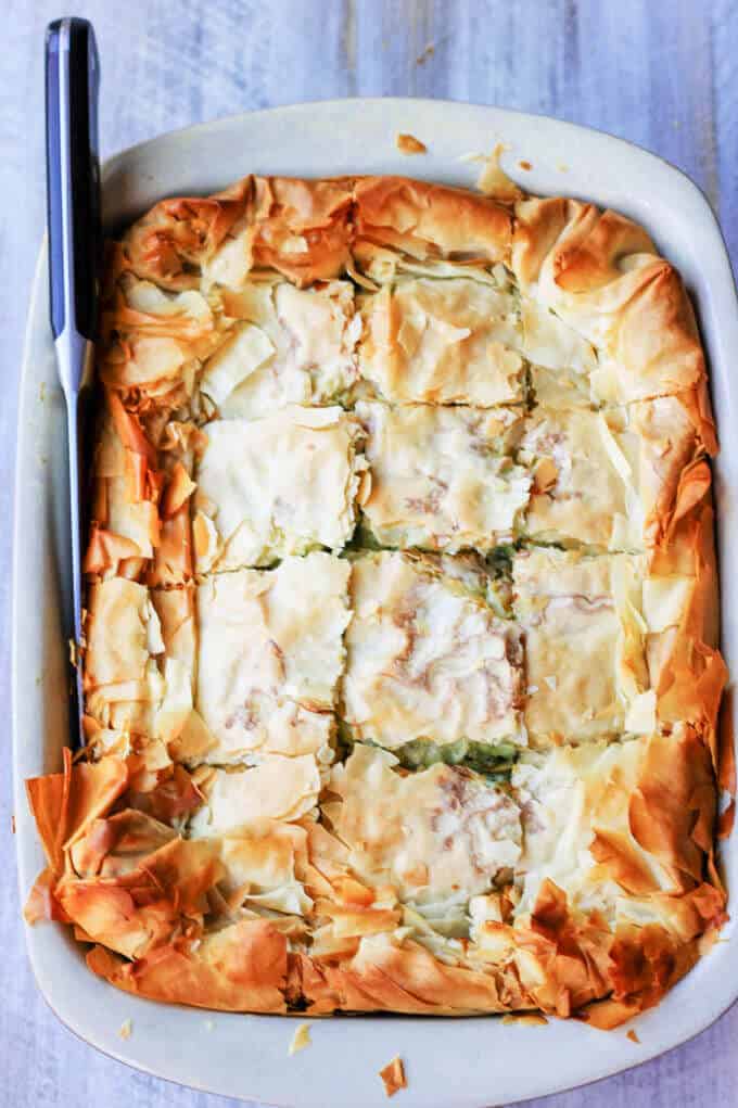 Greek Kolokithopita Pie in a casserole dish with knife on a side