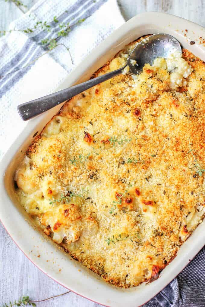 Cauliflower Pasta Bake with Brie and Fontina in a baking dish with spoon