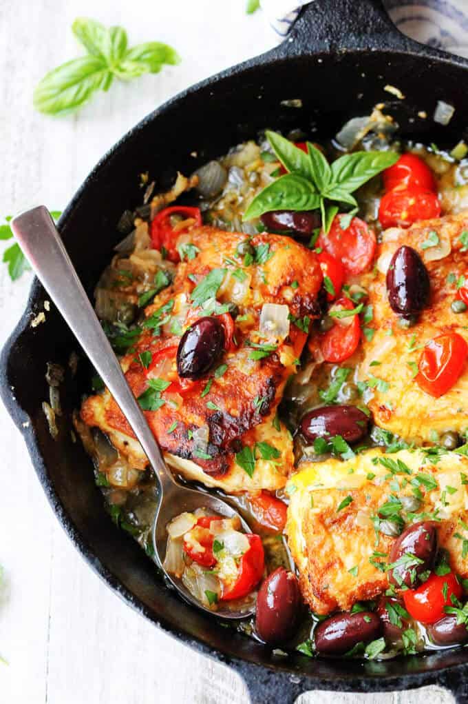 Pan Fried Haddock with Mediterranean Style Sauce in a skillet with spoon