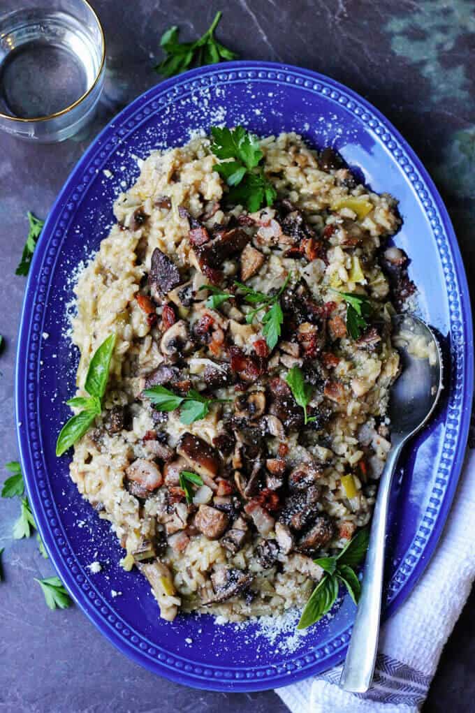 Mushroom Risotto with Bacon on a blue serving plate with spoon