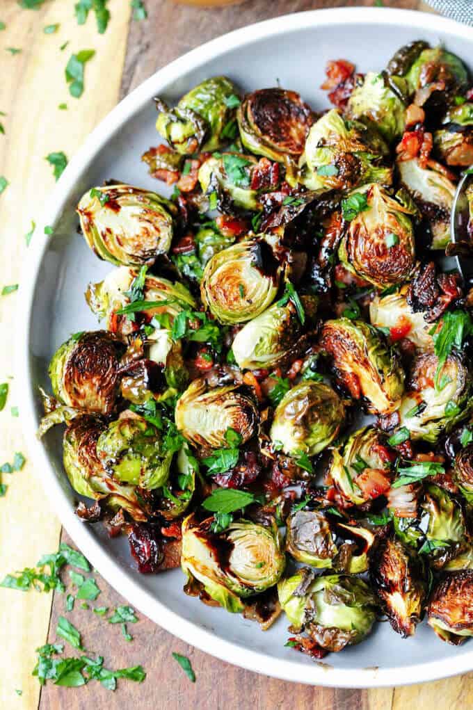 Balsamic glazed Brussels sprouts with bacon and cranberries on a gray plate