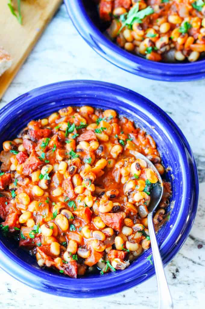 breton beans with sausage and tomatoes on blue plate with spoon