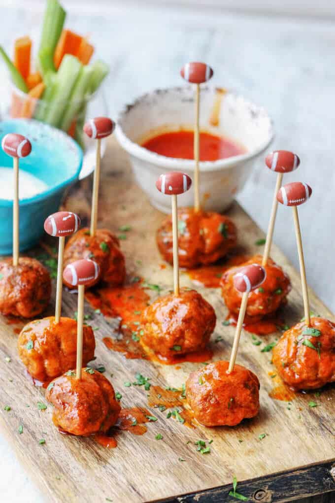 Buffalo Turkey Meatballs with football sticks and hot sauce and blue cheese on a side