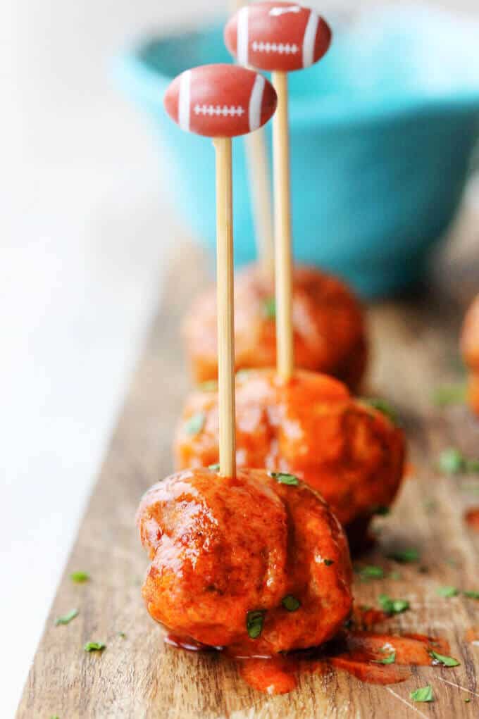 Buffalo Turkey Meatballs with football sticks and blue ball in the back