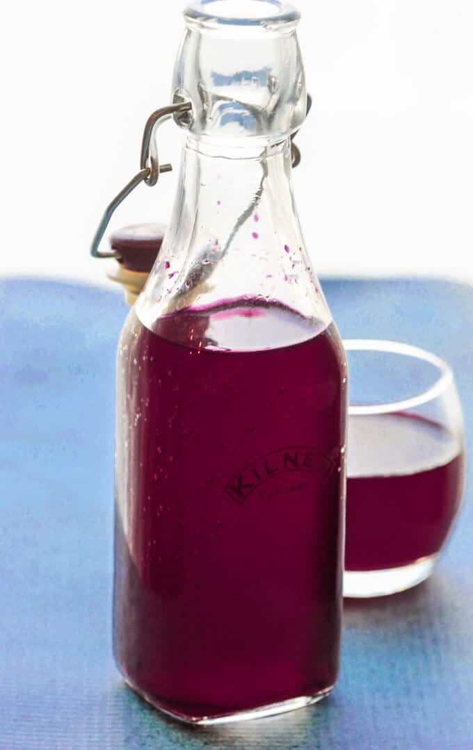 How to make beet kvass - bottle and glass with kvass on blue background