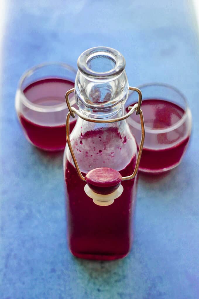 How to make beet kvass - bottle and two glasses with kvass on blue background