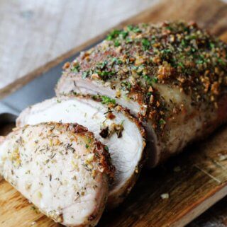 Brown sugar pork loin on cutting board with knife, horizontal shot.