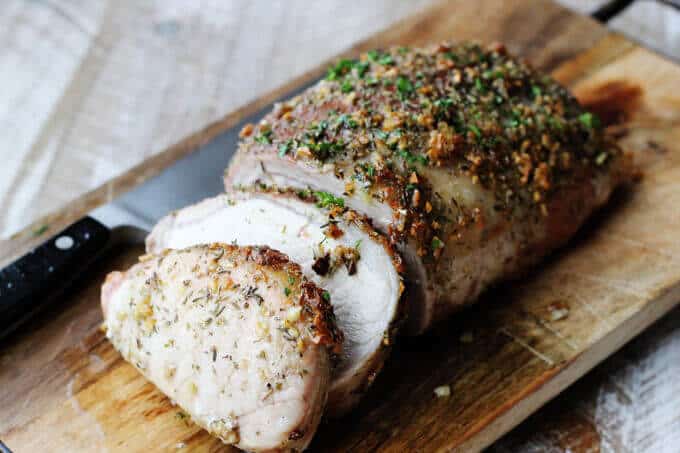 Brown sugar pork loin on cutting board with knife, horizontal shot.