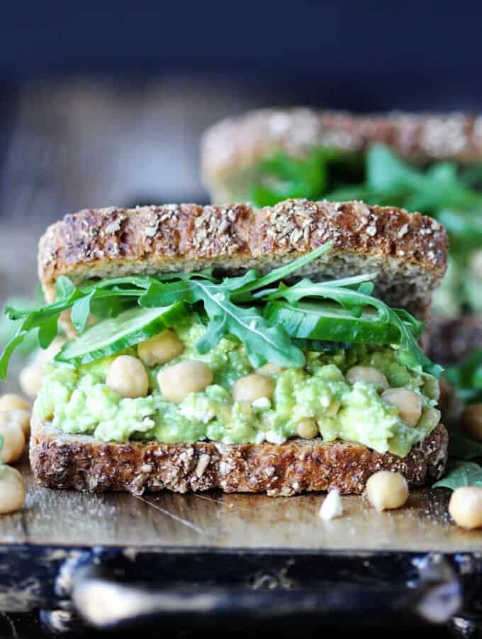 Smashed Chickpea Avocado Feta Sandwich with cucumber and arugula, front close up