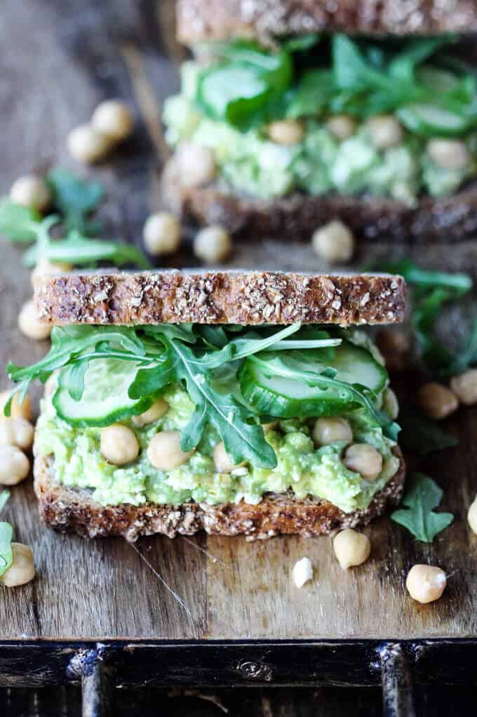 Two avocado chickpea sandwiches on a broad 