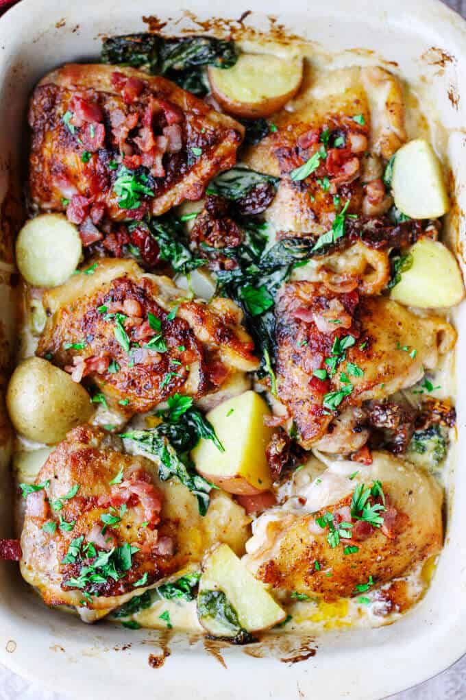 Tuscan chicken and potatoes in baking dish, overhead view 