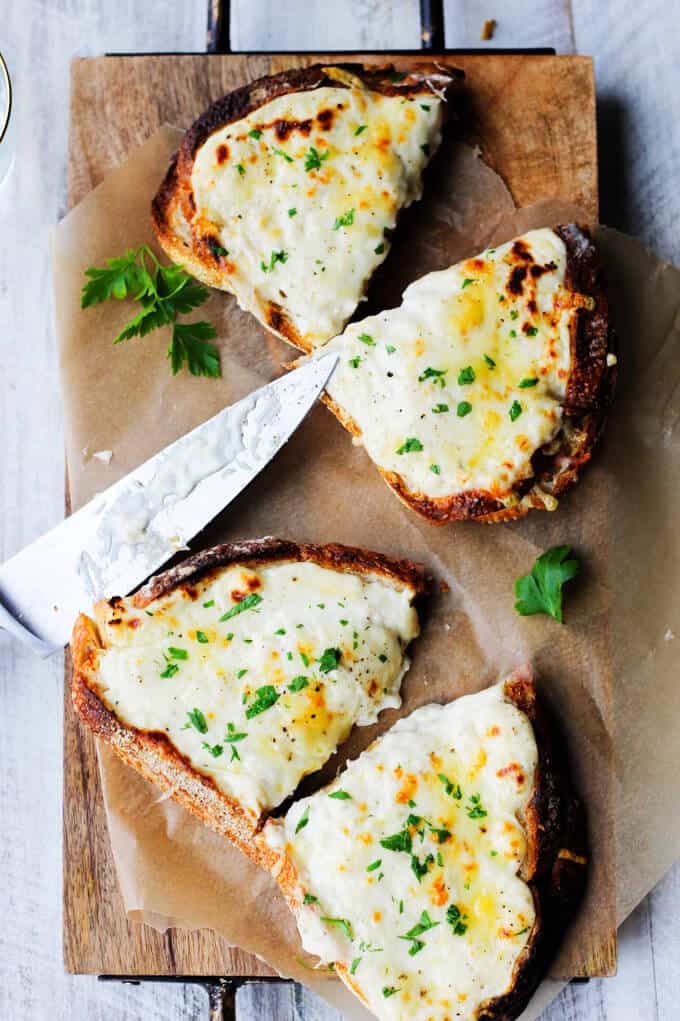 Croque Monsieur ham and cheese sandwich on a board with a knife