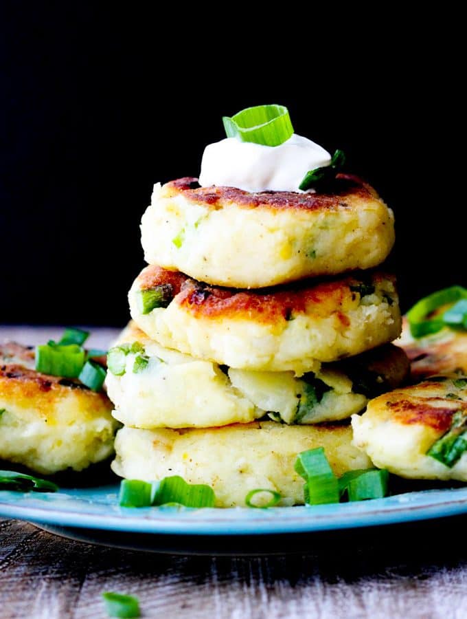 Potato cutlets stack on a blue plate with black background