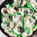 turkey meatballs and asparagus in creamy Alfredo sauce in a pan; overhead horizontal shot