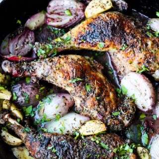 Roasted chicken pieces in a skillet with shallots, garlic and herbs de Provence