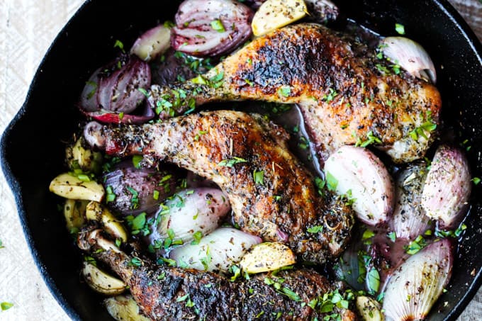 Roasted chicken pieces in a skillet with shallots, garlic and herbs de Provence