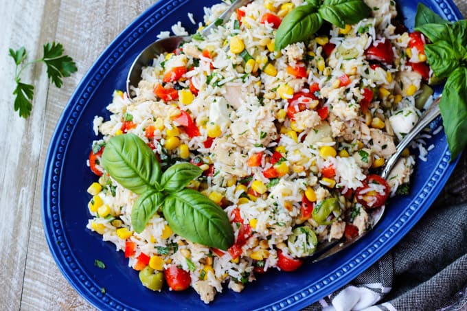 Italian rice salad with tuna on a blue plate with towel on a side