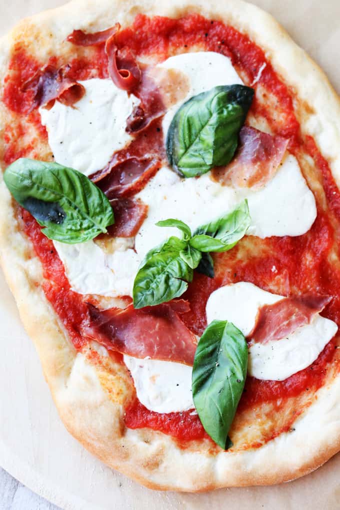 Margherita pizza with basil and prosciutto