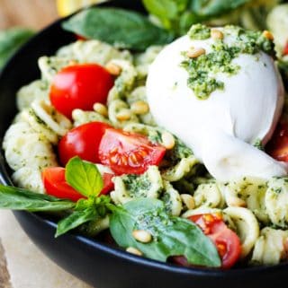 Burrata Cheese on top of pesto pasta with cherry tomatoes