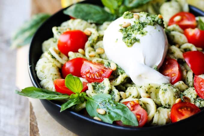 Burrata Cheese on top of pesto pasta with cherry tomatoes