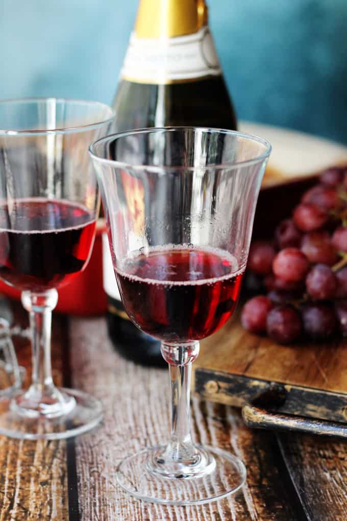 Italian Dessert Wine Brachetto in glasses with bottle and grapes in the back