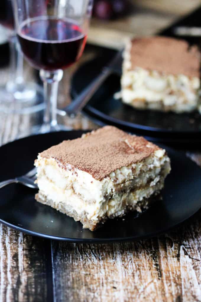 Tiramisu on a plate with Italian Dessert Wine in the back