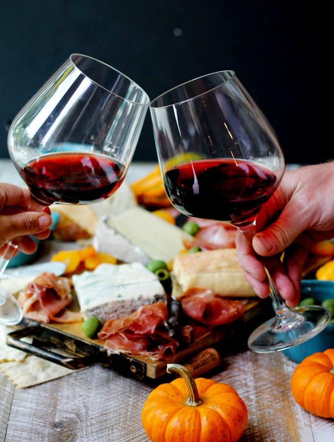 Glasses of red Italian wine and cheese with meat board