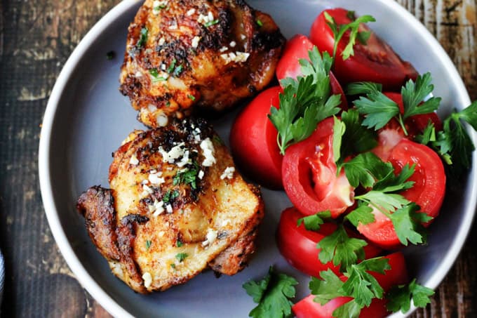 Olive oil chicken on a plate with tomatoes