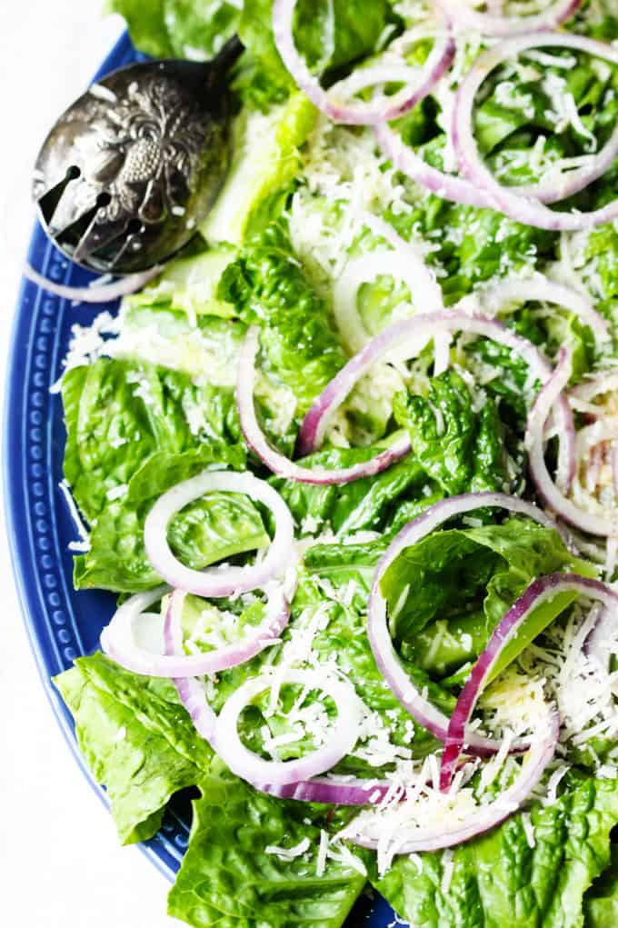 Best green salad with red onions and cheese on a plate