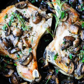 pork chops in cast iron skillet with mushrooms
